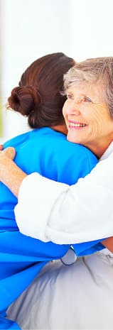 caregiver and old woman hugging each other
